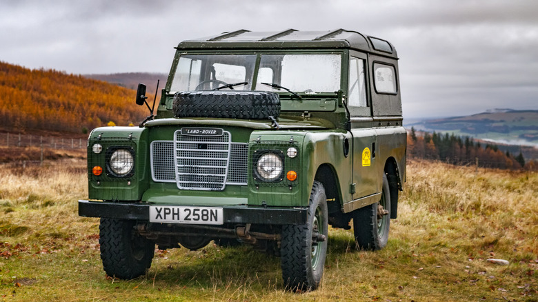 Old Land Rover Defender parked on a mountain in the Scottish Highlands near the town of Pitlochry during Autumn.