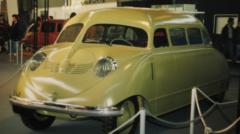 a green scout scarab sitting behind a rope at a car show