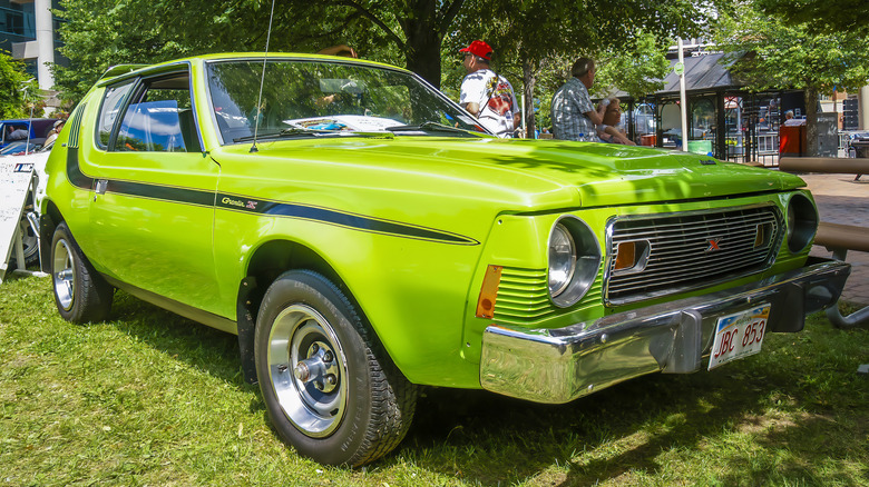 A lime green AMC Gremlin parked on the grass