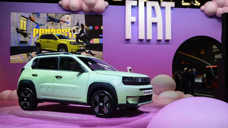 a mint green Fiat Panda on a hot pink car show stand