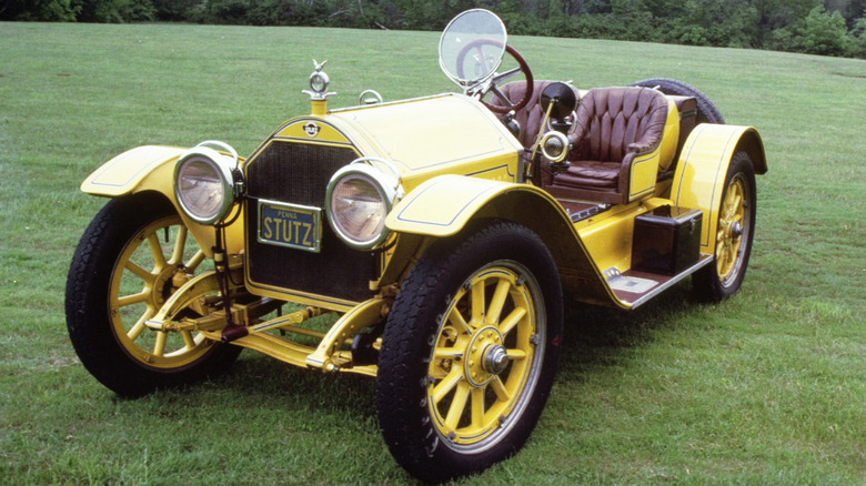A yellow Stutz Bearcat parked on a green lawn