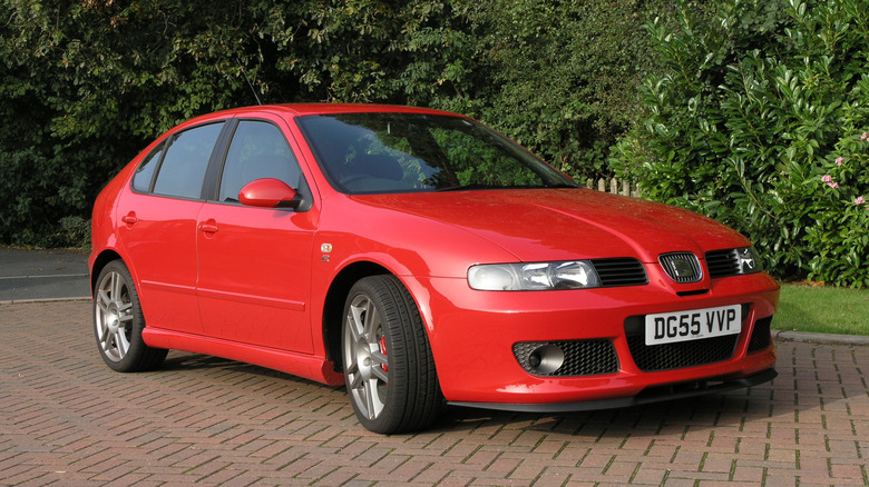 a read SEAT Leon Cupra R parked outside on a brick driveway
