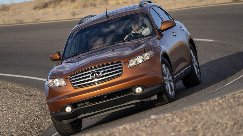 Front view of a copper Infiniti FX driving around a banked corner
