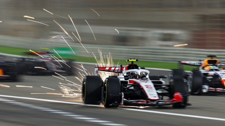 Sparks fly behind Oliver Bearman of Great Britain driving the (87) Haas F1 VF-26 Ferrari on track during day three of F1 Testing at Bahrain International Circuit on February 20, 2026 in Bahrain, Bahrain.