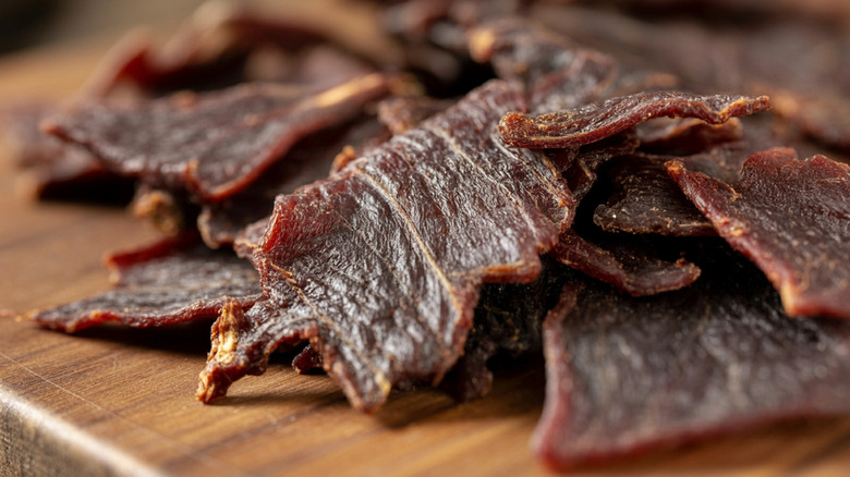  rustic woody committee pinch strips of beef jerky, textured surface, savory dried nutrient snack, macromolecule rich | food, artisan preparation, hearty gourmet photography