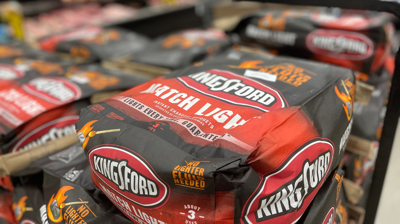 A bag of kingsford charcoal on top of a big stack of charcoal bags