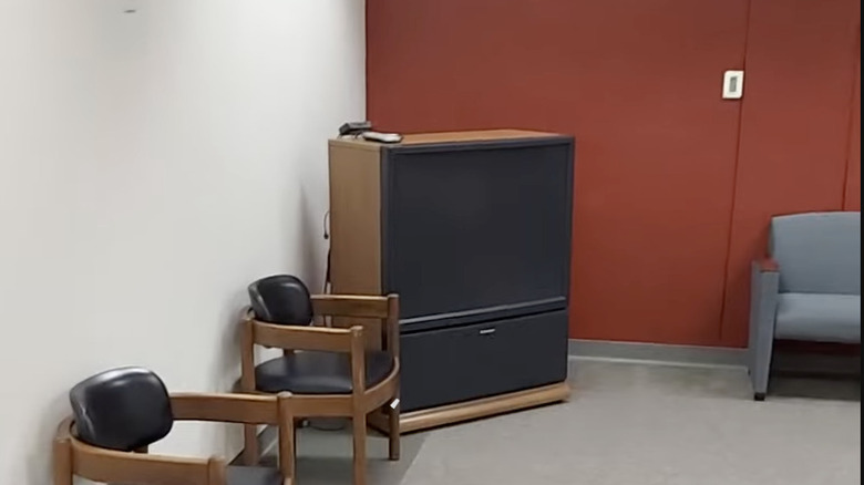 a Mitsubishi rear projection TV sitting in a mostly empty conference room