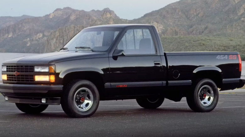 A black Chevy 454 SS truck parked in a parking lot in a bay