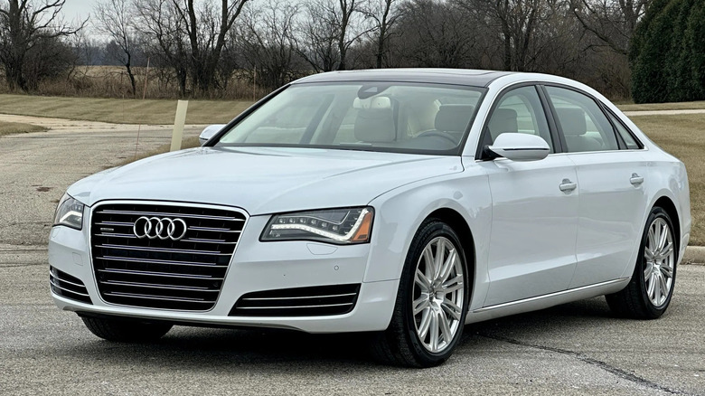front three-quarters shot of a white Audi A8 with its DRLs on