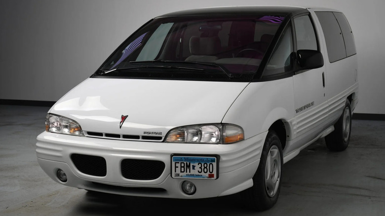 Front three-quarters shot of a white Pontiac Trans Sport parked in front of a white wall