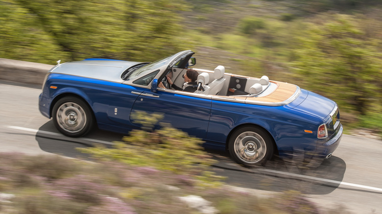 Side view of a blue Rolls-Royce Phantom Drophead with the roof down