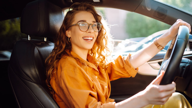 Stylish woman driving a car. The traveler is the driver. Automobile travel. Sharing a car. Lifestyle concept.