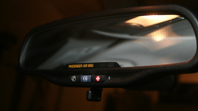 A rear-view mirror with a blue OnStar button