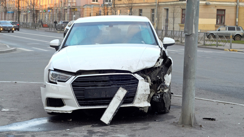 Lower point of view of bizarre car wreck in downtown Philadelphia. Car appears to be taking off only to be stopped by a light pole. A lovely non-fatal early morning autumn accident.