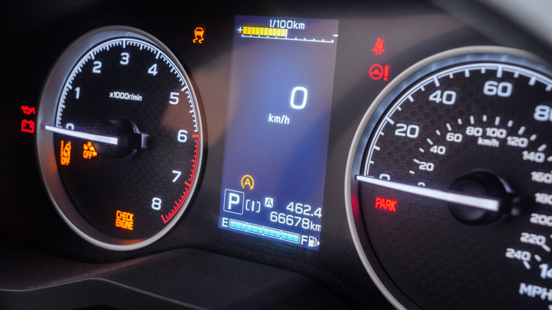 Warning lights illuminating car dashboard, gauges displaying zero speed and critical vehicle information.