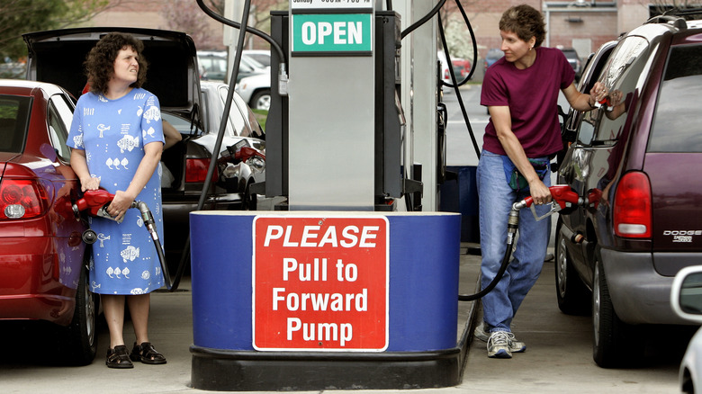 Two women fill up their cars with gas at a Costco gas station