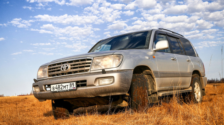  Grey 4x4 conveyance Toyota Land Cruiser 100 astatine nan barren grassland.