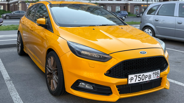 St-Petersburg, Russia, June 23, 2025: Yellow Ford Focus ST 4-generation for the European market. Stands on Parking slot. Yellow Ford Focus ST Turnier sport estate car parked on street at the evening.
