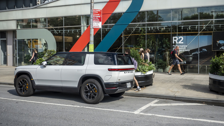 Rivian R2 parked on the street next to pedestrians