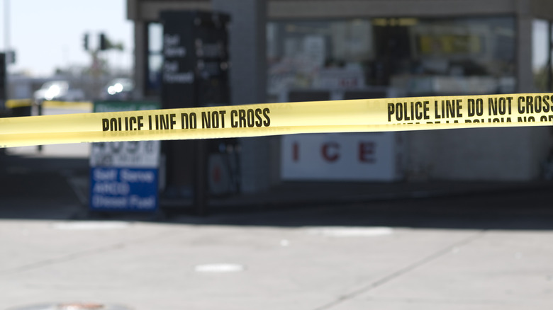 Police secure crime scene with yellow crime scene tape that surrounds the gas station, securing the integrity of the evidence.