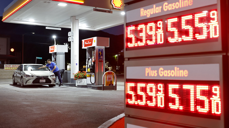 A customer washes their windshield near gas prices displayed at a gas station on July 7, 2026 in Pasadena, California.
