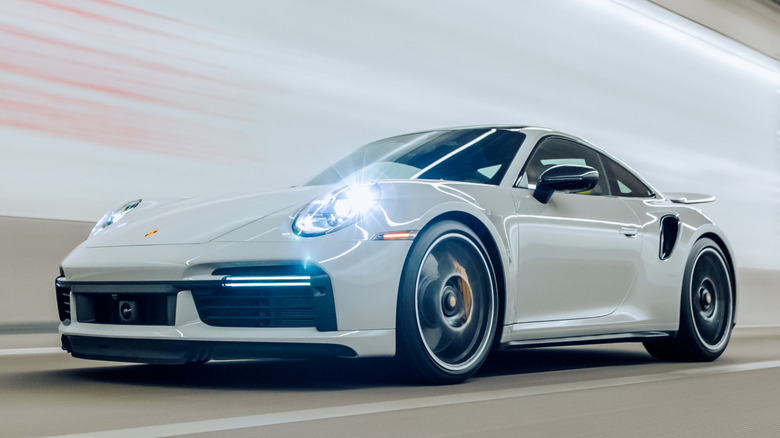 A white Porsche 911 being driven inside a tunnel.