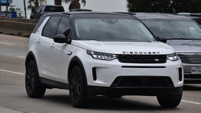 A white Land Rover Discovery on a roadway.