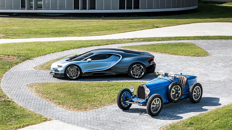 Blue 1924 Bugatti Type 35 and two-tone blue 2024 Bugatti Tourbillon parked together in front of a modern building
