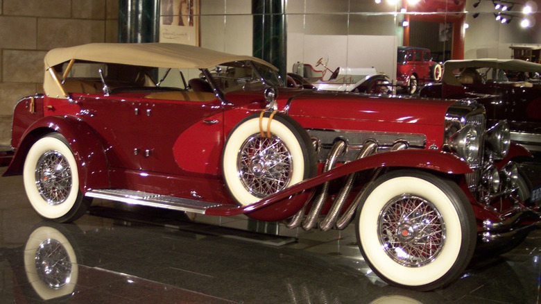 Red 1935 Convertible SJ La Grande Dual-Cowl Phaeton seen from left displayed in a museum
