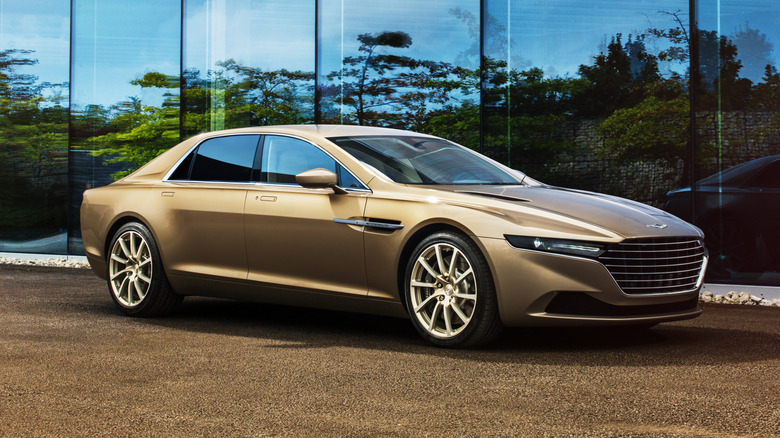 Tan Lagonda Taraf sedan seen from right front parked in front of a mirrored building