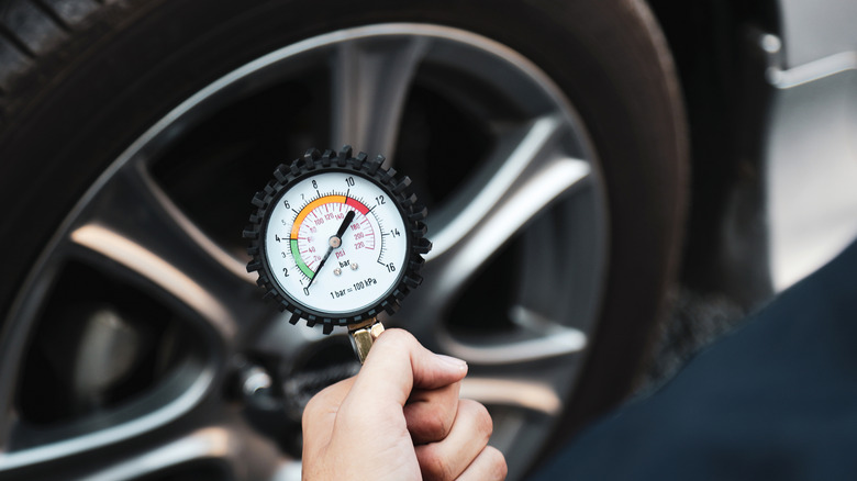 Checking the pressure on a tire.