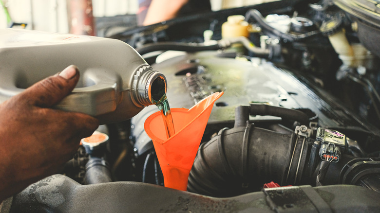 A mechanic adding fluid.