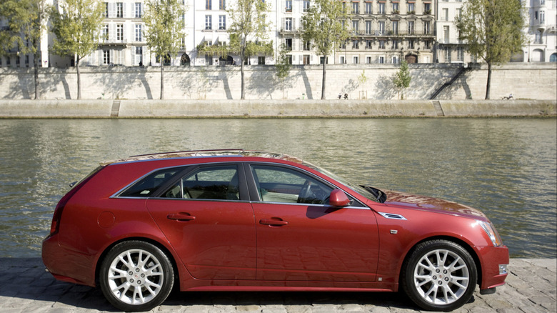A red CTS wagon parked in front of a canal in Quebec