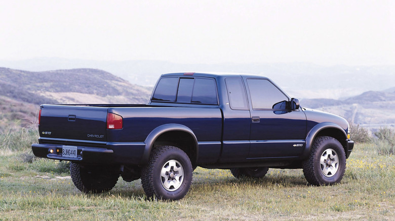 A s-10 chevrolet truck parked in a field with hills rolling into the distance