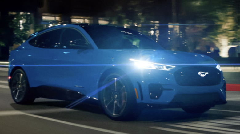 A blue Ford Mustang Mach-E being driven at night