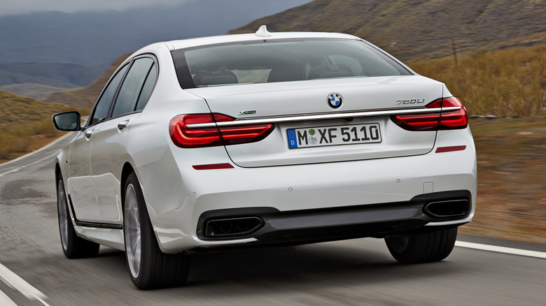 A white BMW 760Li driving down the highway