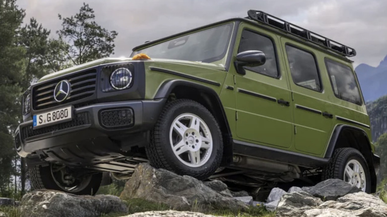 A green Mercedes-Benz G550 Edition Stronger Than The 1980s parked on a rock with mountains behind it