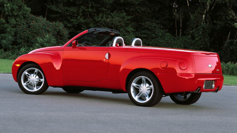 A red Chevy SSR parked in front of trees