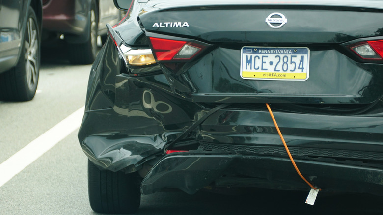 July 22, 2025 - A damaged Nissan Altima on its rear end significantly compromised with a bungee cord