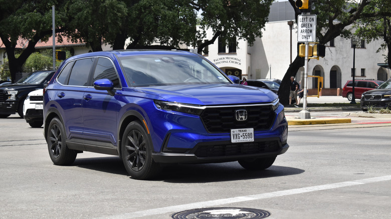 A blue Honda CR-V crosses an intersection.