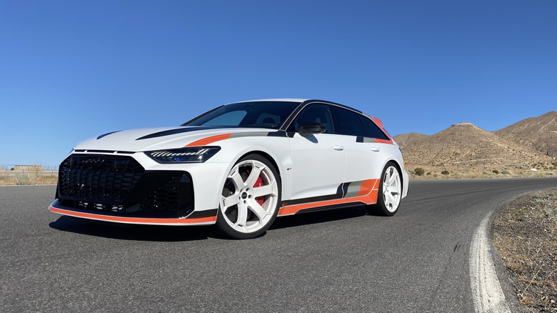 front three-quarters shot of a white Audi RS6 Avant GT parked on Willow Springs Raceway in front of a blue sky and mountains