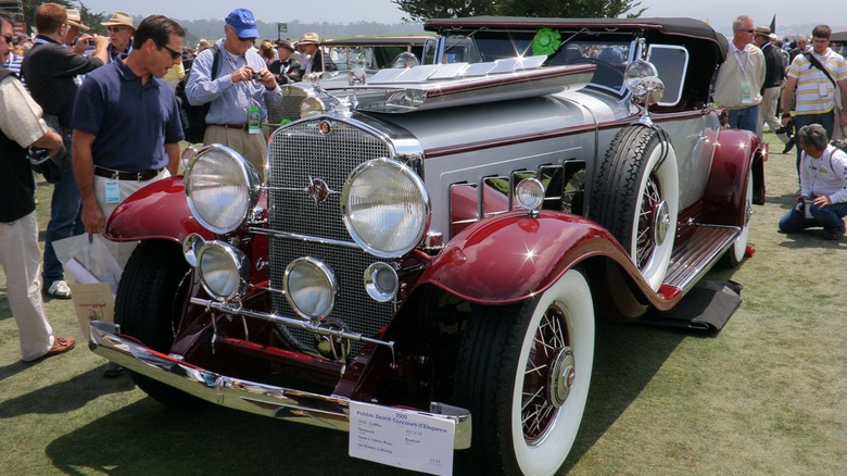 A red and gray 1930 Cadillac 452 at a car show
