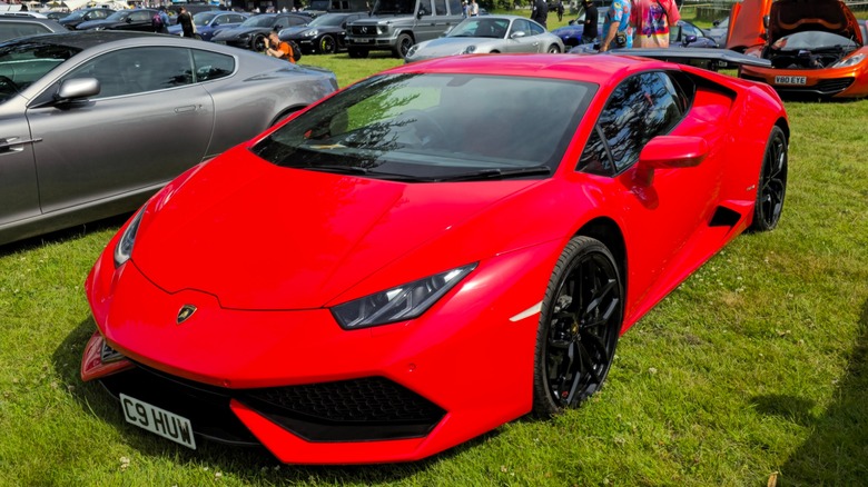 A red 2014 Lamborghini Huracán LP 610-4 parked on grass at a car show