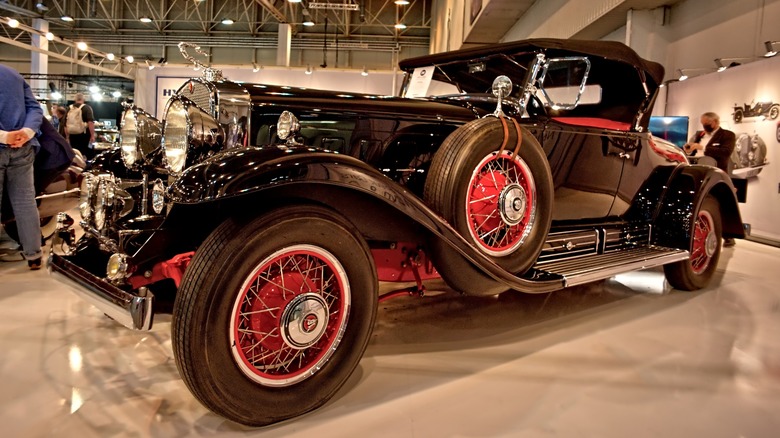 A black 1930 Cadillac 452 parked at an indoor car show