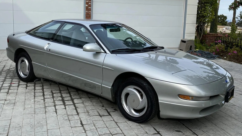 Front three-quarters shot of a silver Probe SE parked on gray brick in front of white garage doors