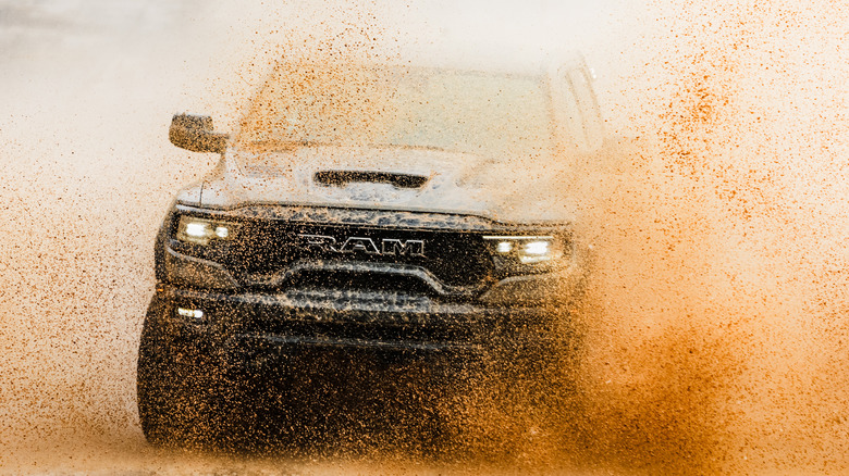 A Ram 1500 TRX driving through mud