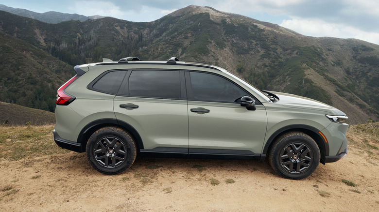 Side view of a green Honda CR-V in front of mountains