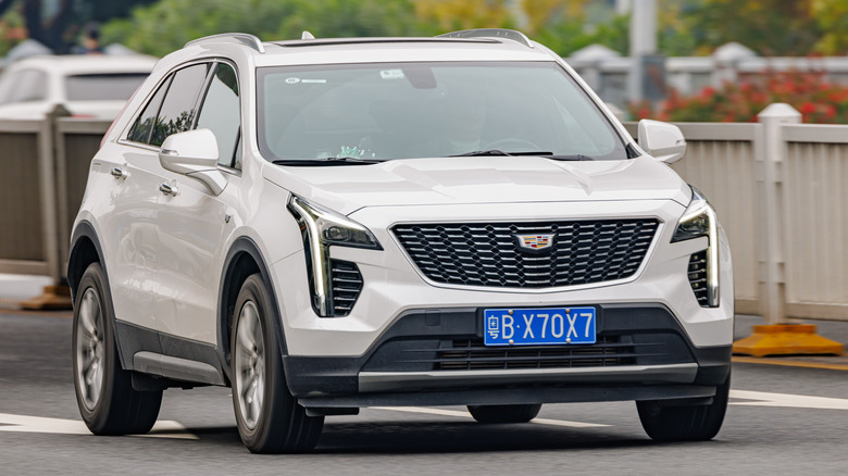 A front three quarters shot of a white Cadillac XT4 driving in China