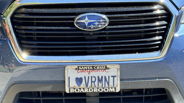 a close-up of the front of a blue Subaru Ascent with a California license plate that says 'love Vermont'