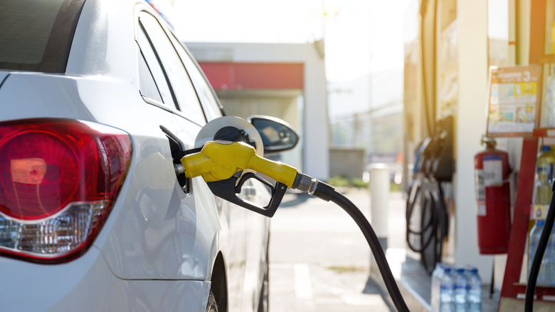Car filling up with fuel at gas station.